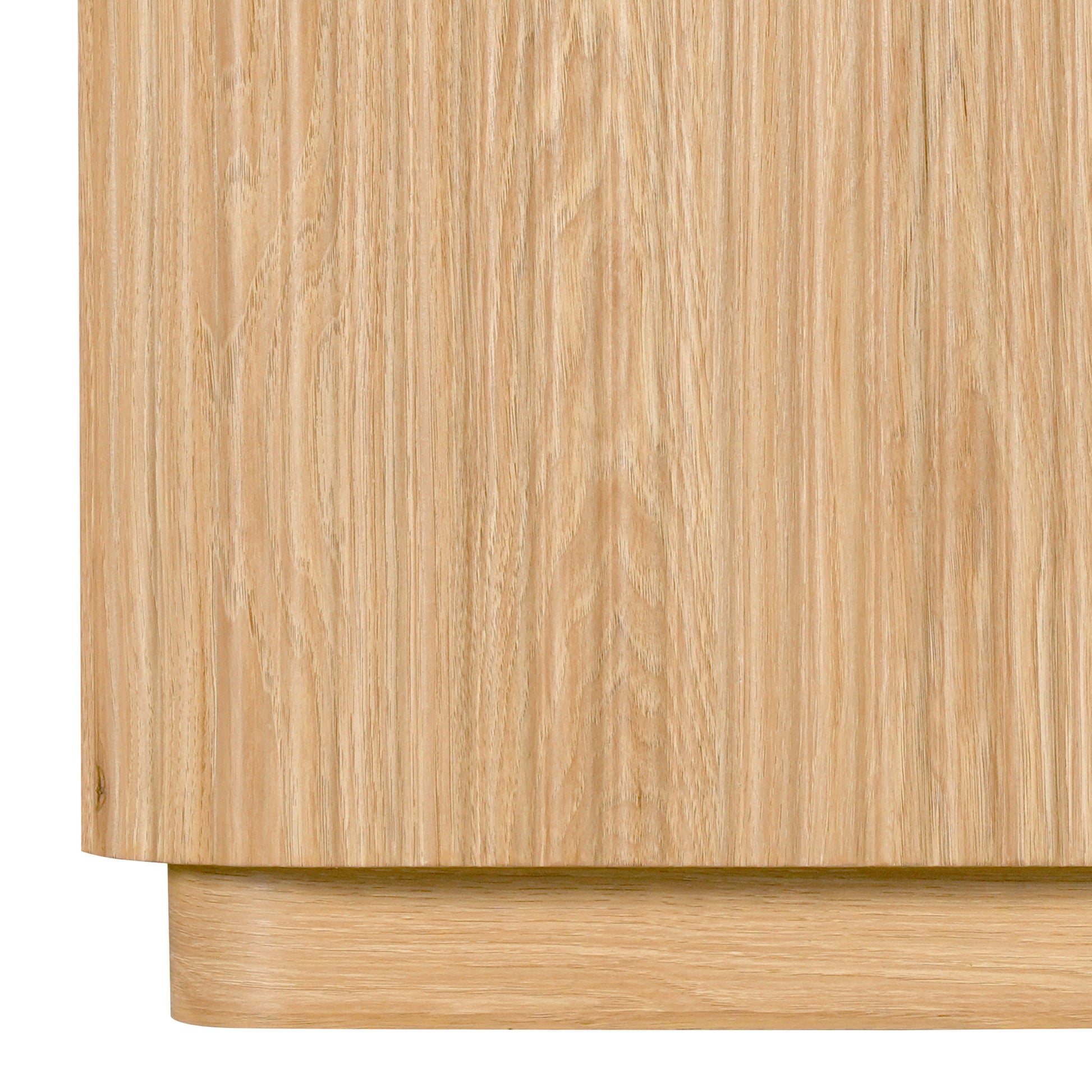 Close-up of the lower part of a light wood cabinet on white background