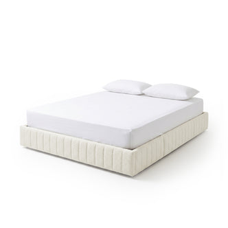 Modern upholstered bed with white mattress and pillows on a white background