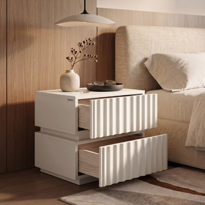 White textured nightstand styled in a modern bedroom next to a bed.