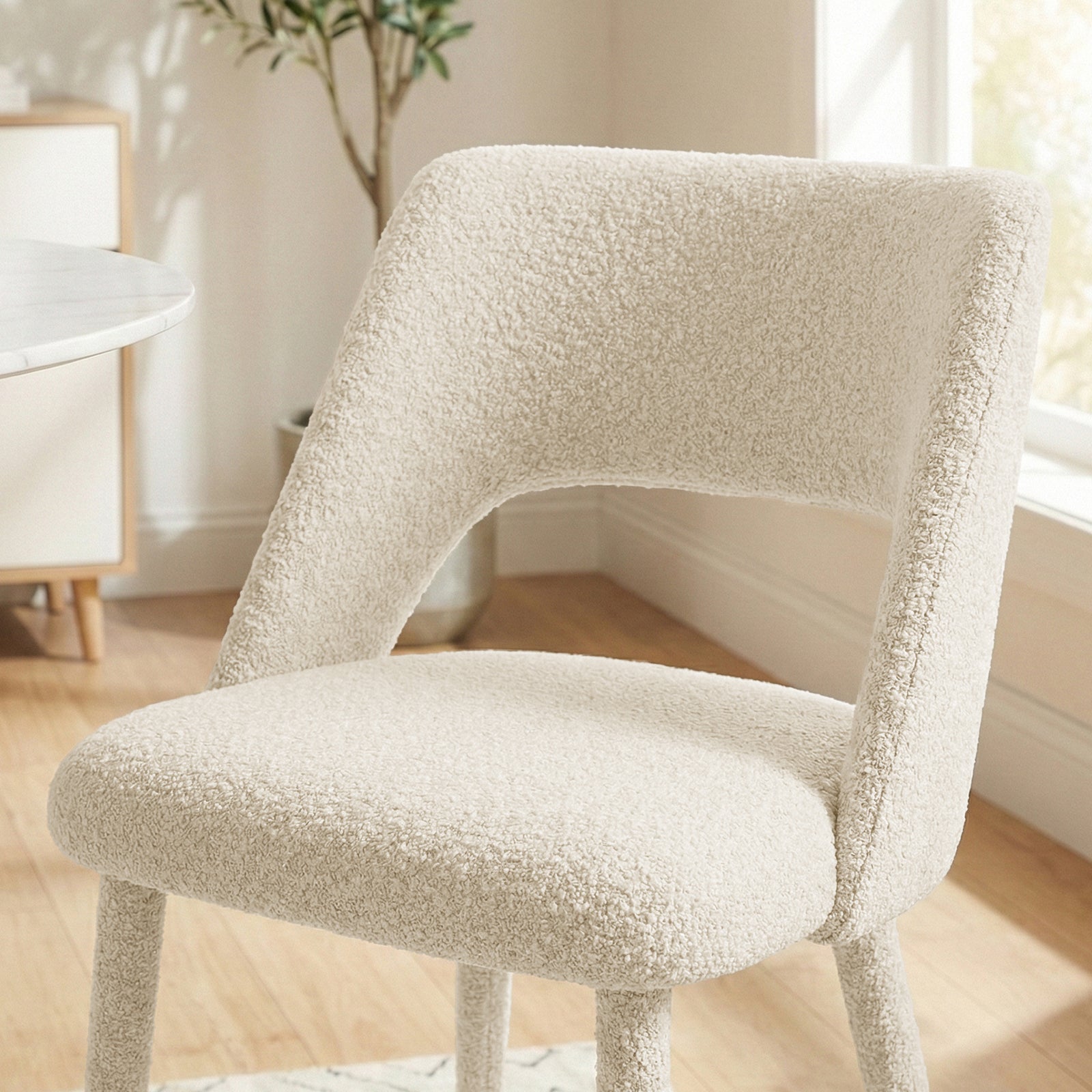 Cream chair in lifestyle setting with partial top and leg cropped