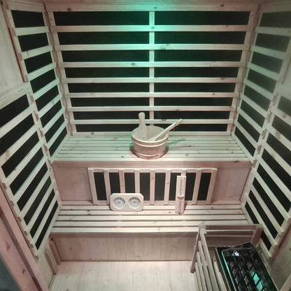 Luxo Kiima 3 Person Hybrid Finnish Outdoor Sauna in Natural features two-tier slatted wood benches, a sauna bucket with ladle, thermometer/hygrometer, hourglass, and a traditional sauna heater with stones.