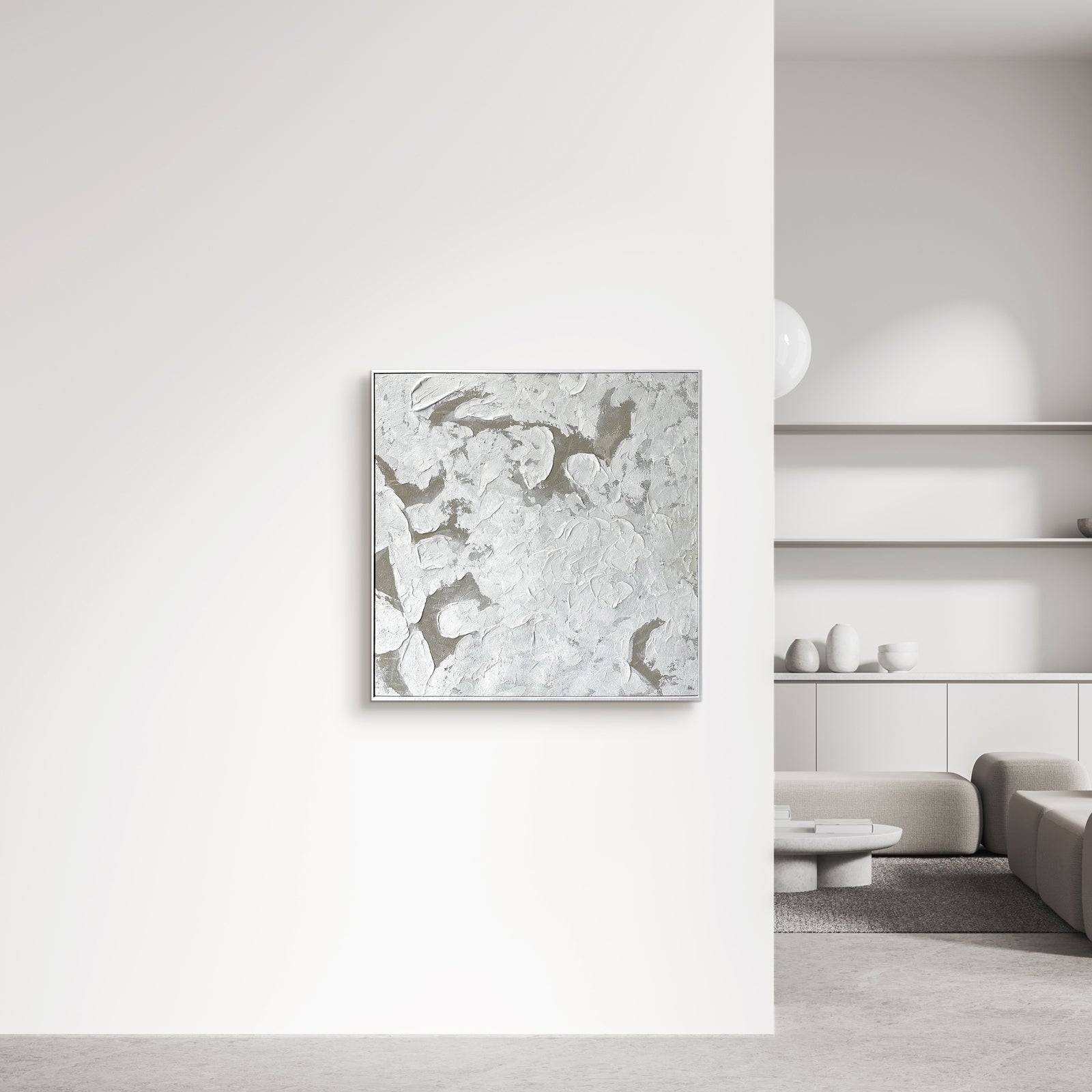 Luma Framed Canvas Wall Art 105 x 105cm in White, featuring a textured abstract design, hangs on a white wall above a beige sofa, complemented by a modern concrete coffee table.
