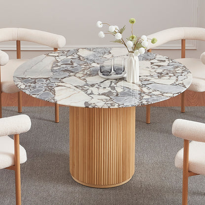 Gracie 120cm Round Marble Dining Table in Natural features a white marble top with gray-brown veining on a fluted wood base, surrounded by four cream boucle armchairs, set on a gray rug.