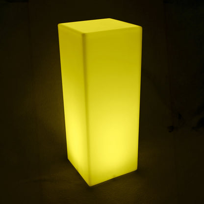 80cm Outdoor Solar LED Column Light glowing warmly, standing upright. A cuboid-shaped, translucent lamp provides ambient lighting, ideal for outdoor use, showcasing a sleek, modern design.