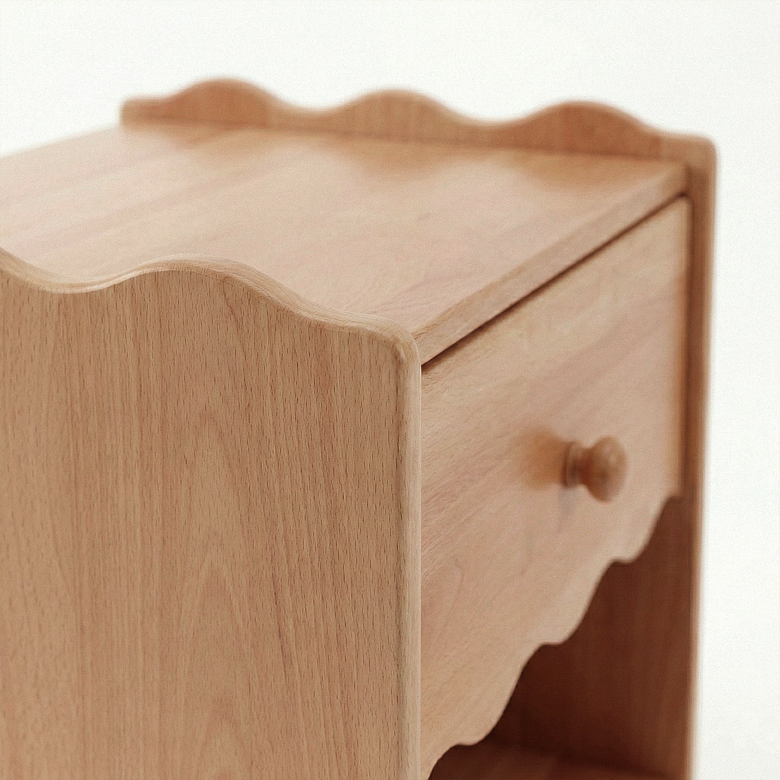 Partial view of wooden nightstand showing drawer and shelf on white background