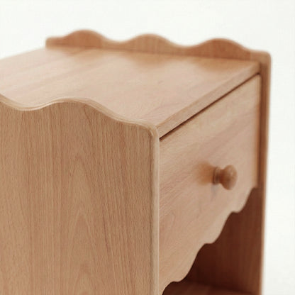 Partial view of wooden nightstand showing drawer and shelf on white background