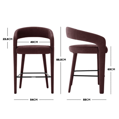 Eisha Velvet Bar Stool Set of 2 in Dark Plum, showing front and side views. Features deep burgundy velvet upholstery, curved open-back design, tapered legs, and black metal footrest with key measurements highlighted.