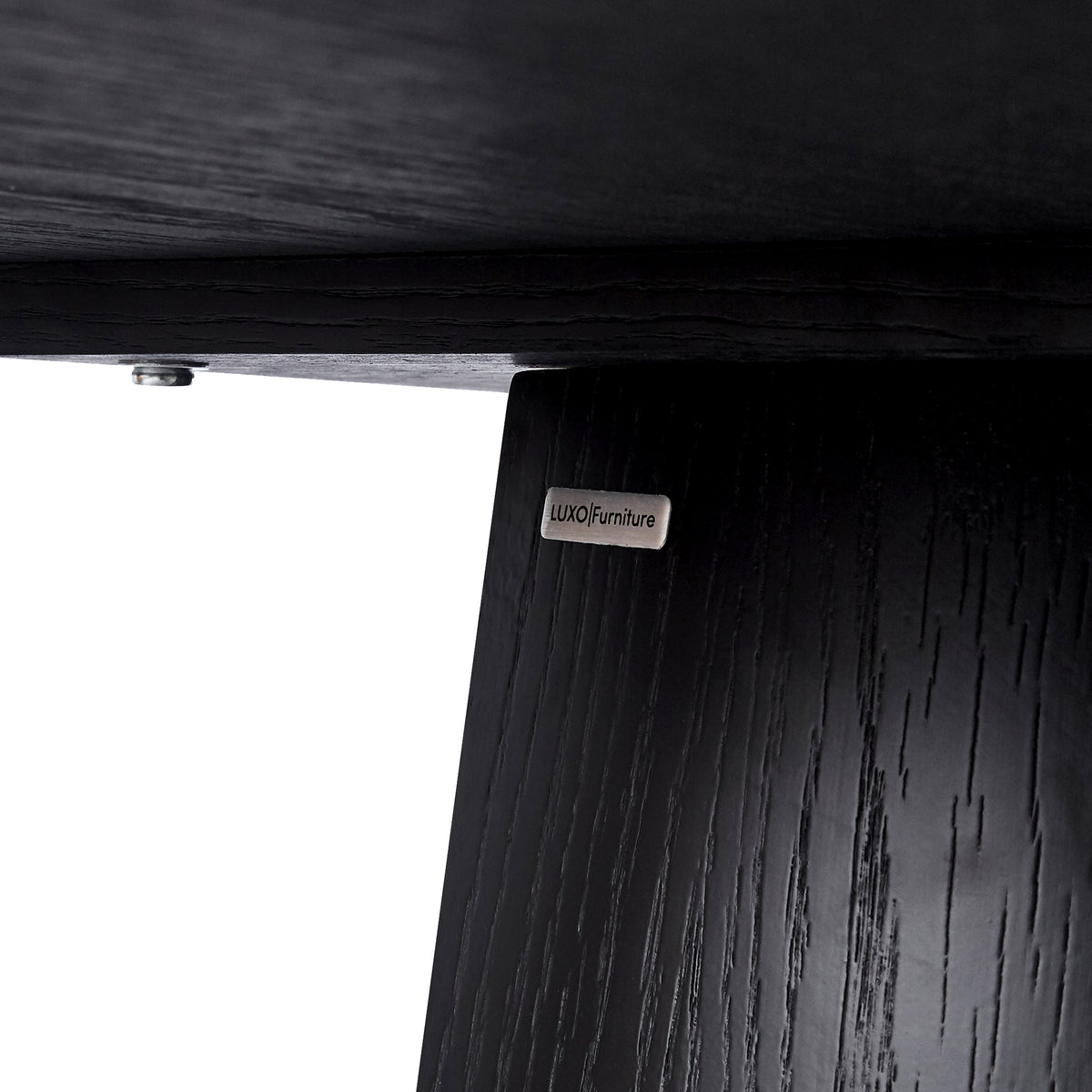 Close-up of the underside and leg joint of dark wood furniture with a brand plate