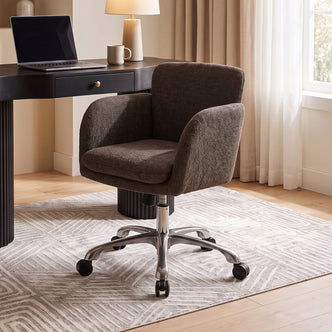 Brown upholstered office chair in a home office with desk and lamp