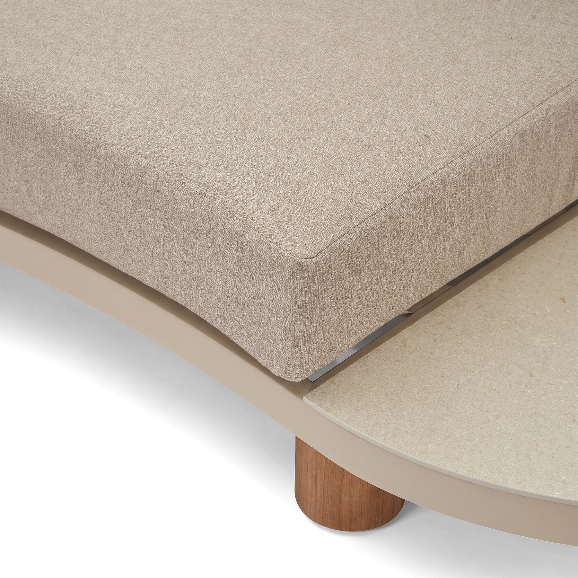 Close-up detail of beige upholstered furniture corner with wooden leg on a white background