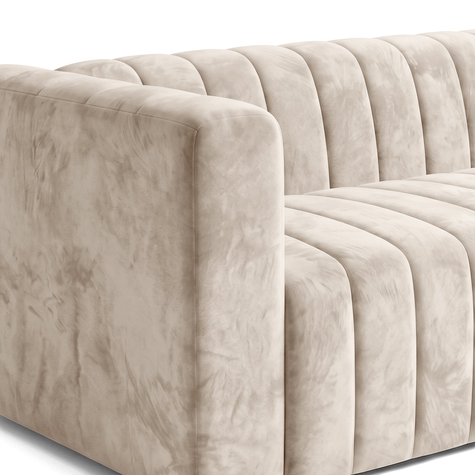 Close view of the arm and seat of a beige channel-tufted sofa on a white background