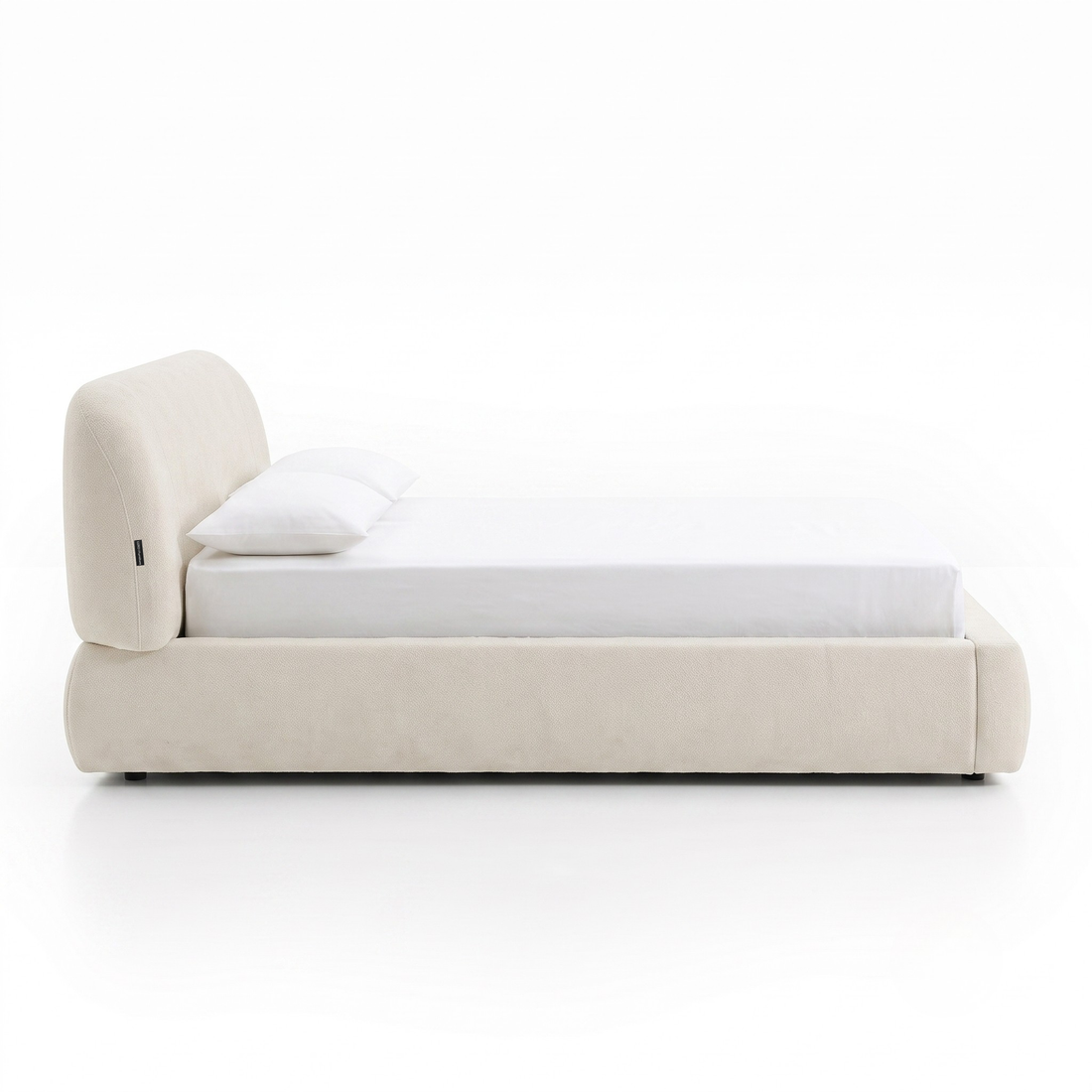 Side profile of a modern upholstered bed on a white background