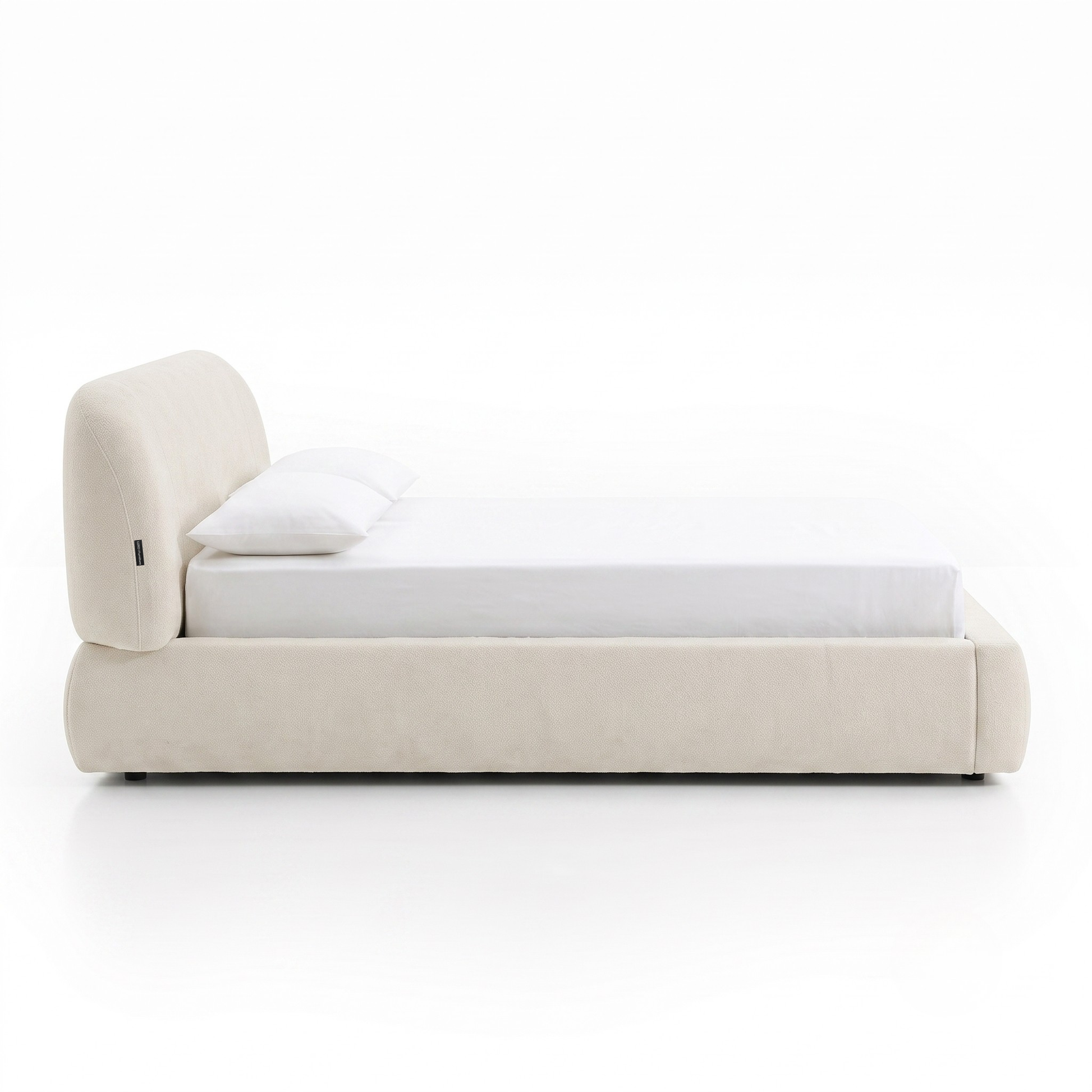 Side profile of a modern upholstered bed on a white background