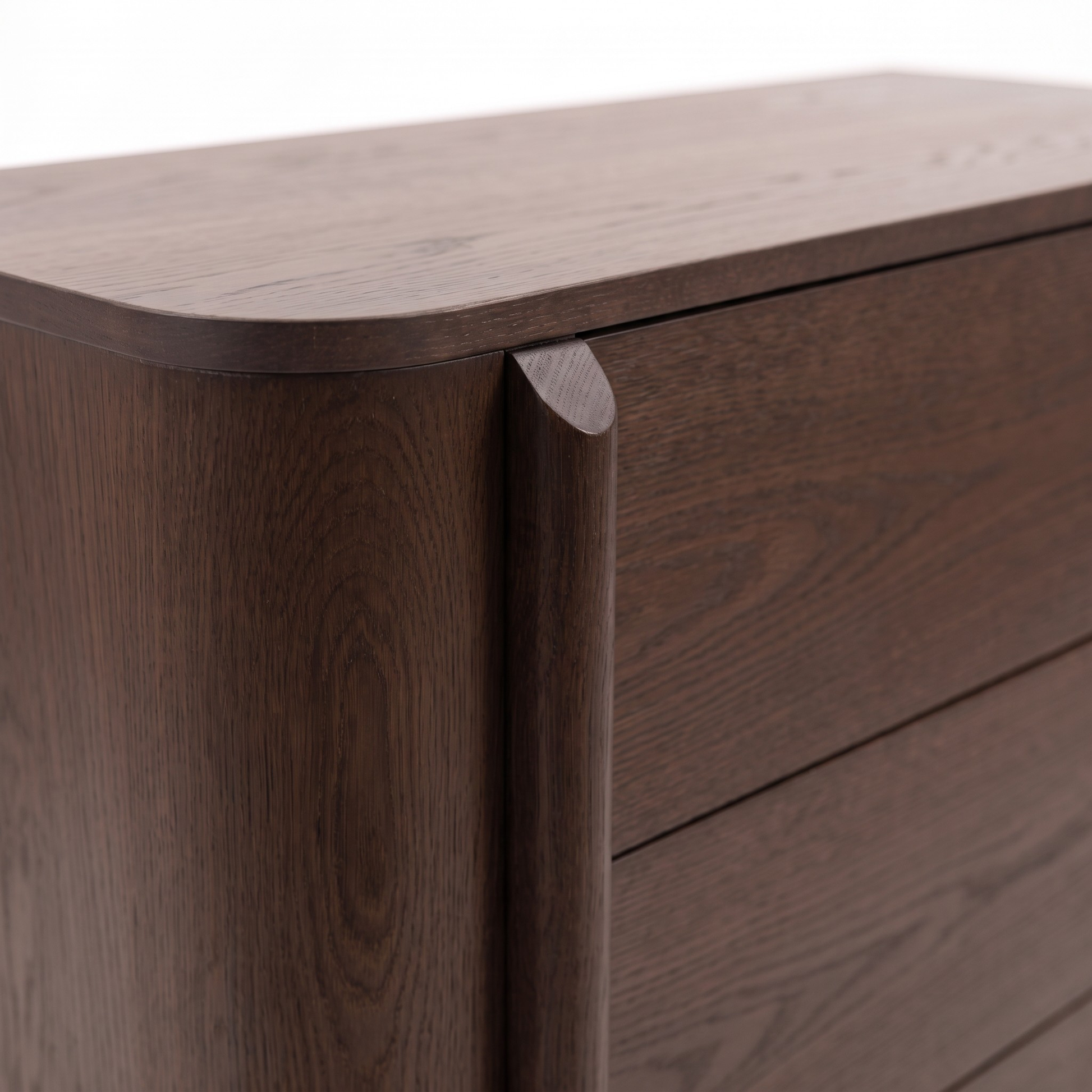 Close-up of the corner and drawer front of a dark wood dresser