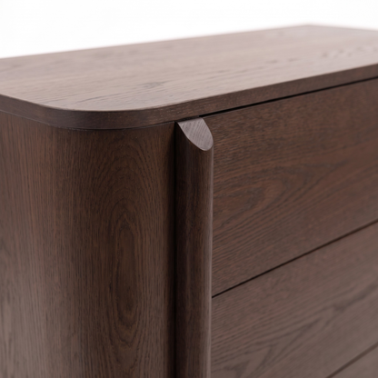 Close-up of the corner and drawer front of a dark wood dresser