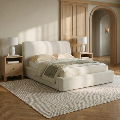 Upholstered bed styled in a warm modern bedroom with nightstands and lamps