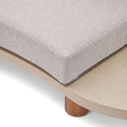 Close-up of a furniture corner with upholstered fabric and wooden leg on a white background.
