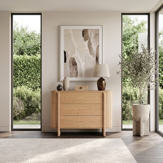 Wooden sideboard in a bright modern room with windows and decor