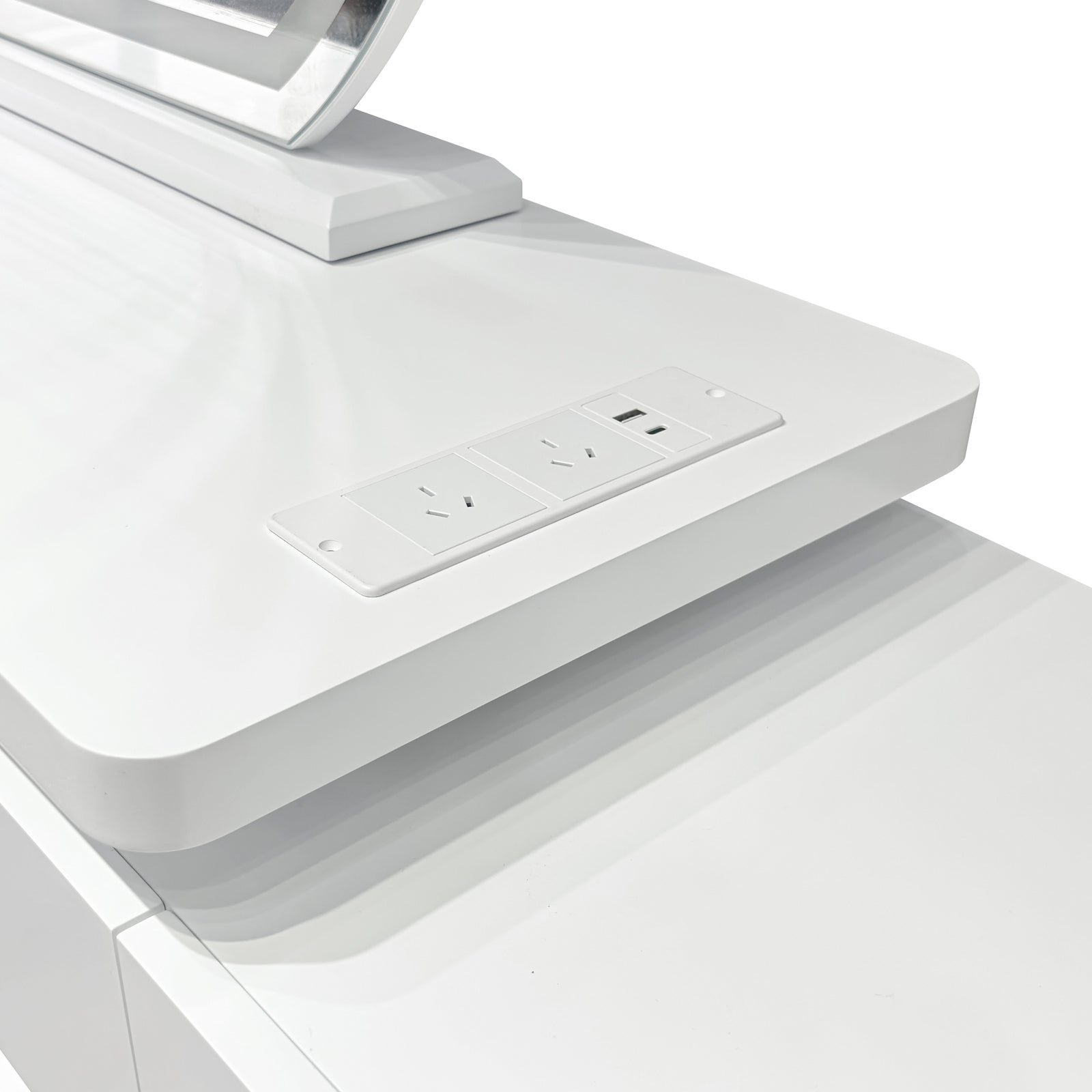Close-up of the Alora LED Mirror Makeup Vanity Table with Storage in White, featuring a built-in power module with two three-pin outlets and a USB port, visible near the monitor stand base.