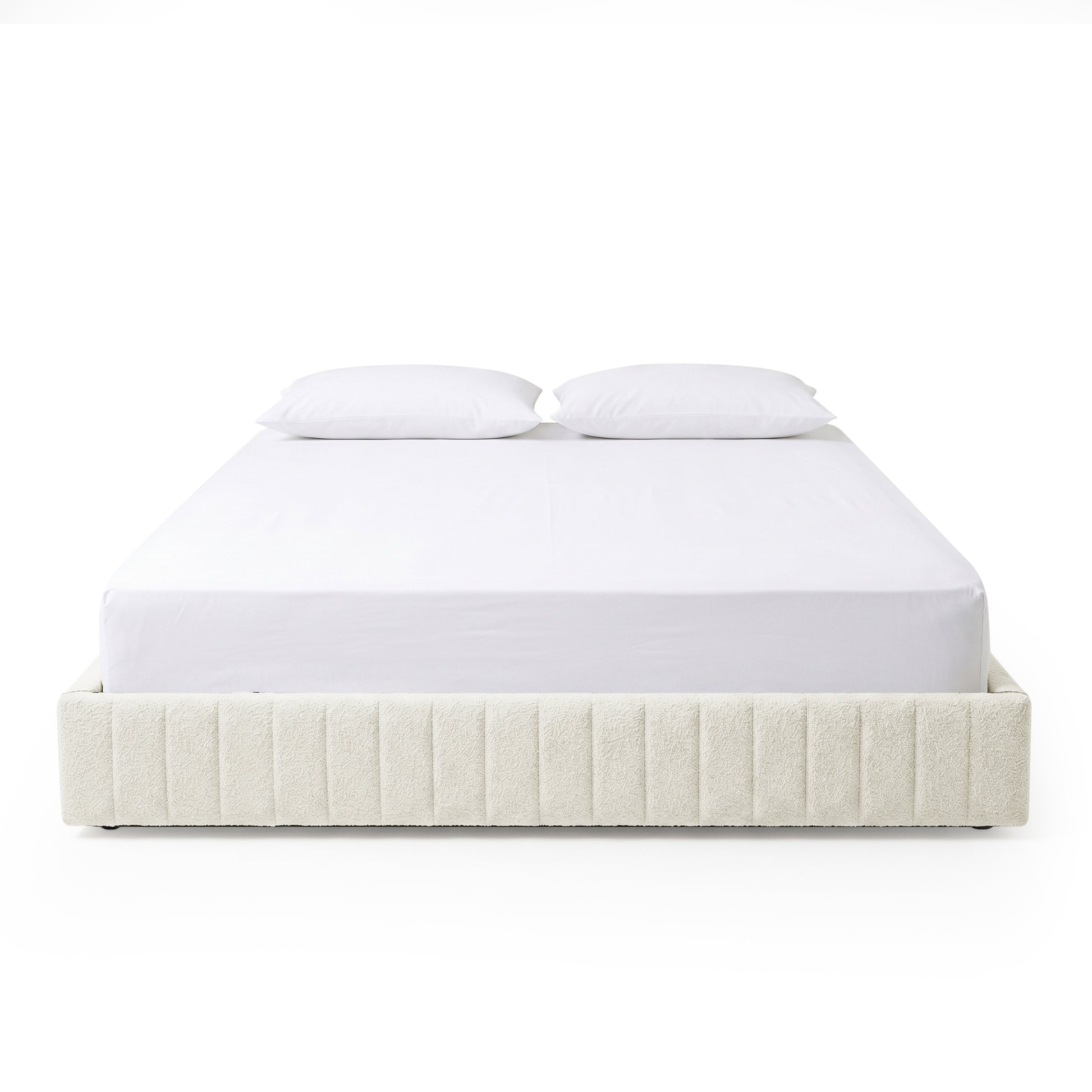 Front-facing upholstered bed with white bedding on white background