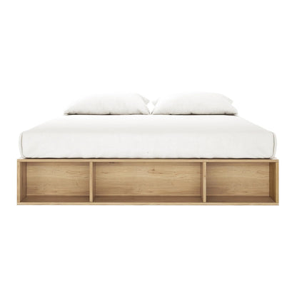 Eulalia King Platform Bed Base with Drawers in Oak features a sleek, low-profile design with a light wood base, white mattress, and pillows, plus three open shelves for storage.