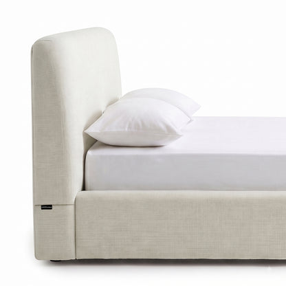 Side view close-up of a modern upholstered bed on a white background