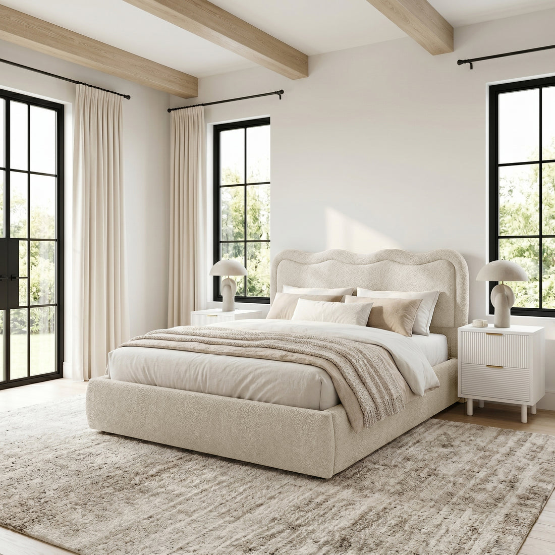 Upholstered bed in a bright, styled bedroom with windows and décor