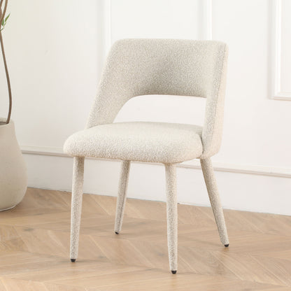 Cream accent chair in styled room with herringbone floor and neutral decor