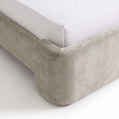 Close-up of upholstered bed corner and mattress edge on white background