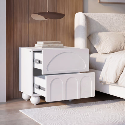 Modern white nightstand with geometric drawer fronts styled in a bedroom.