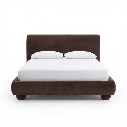 Full upholstered bed on a white background with white bedding and pillows