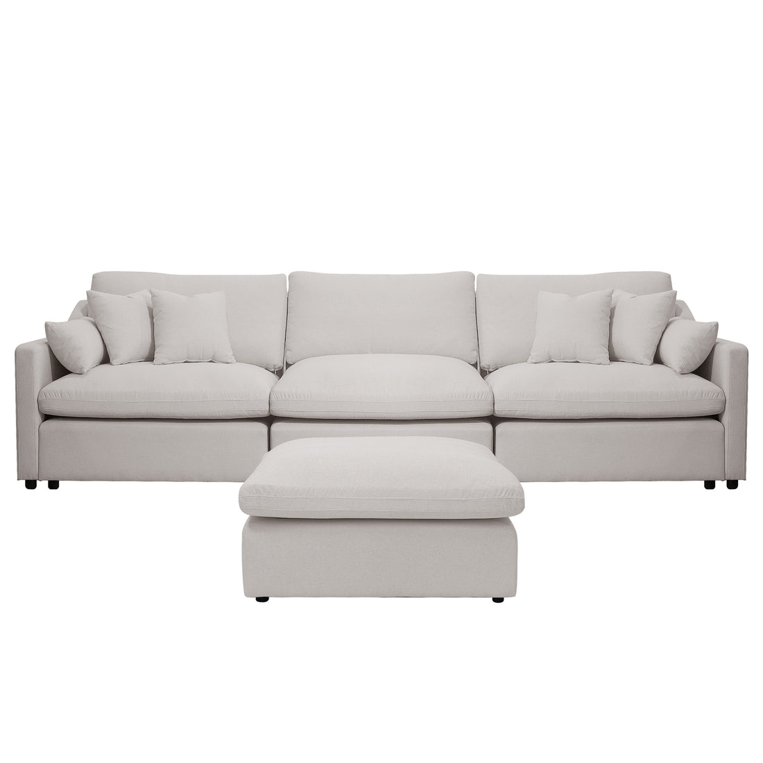Light beige upholstered sofa with ottoman and pillows on a white background