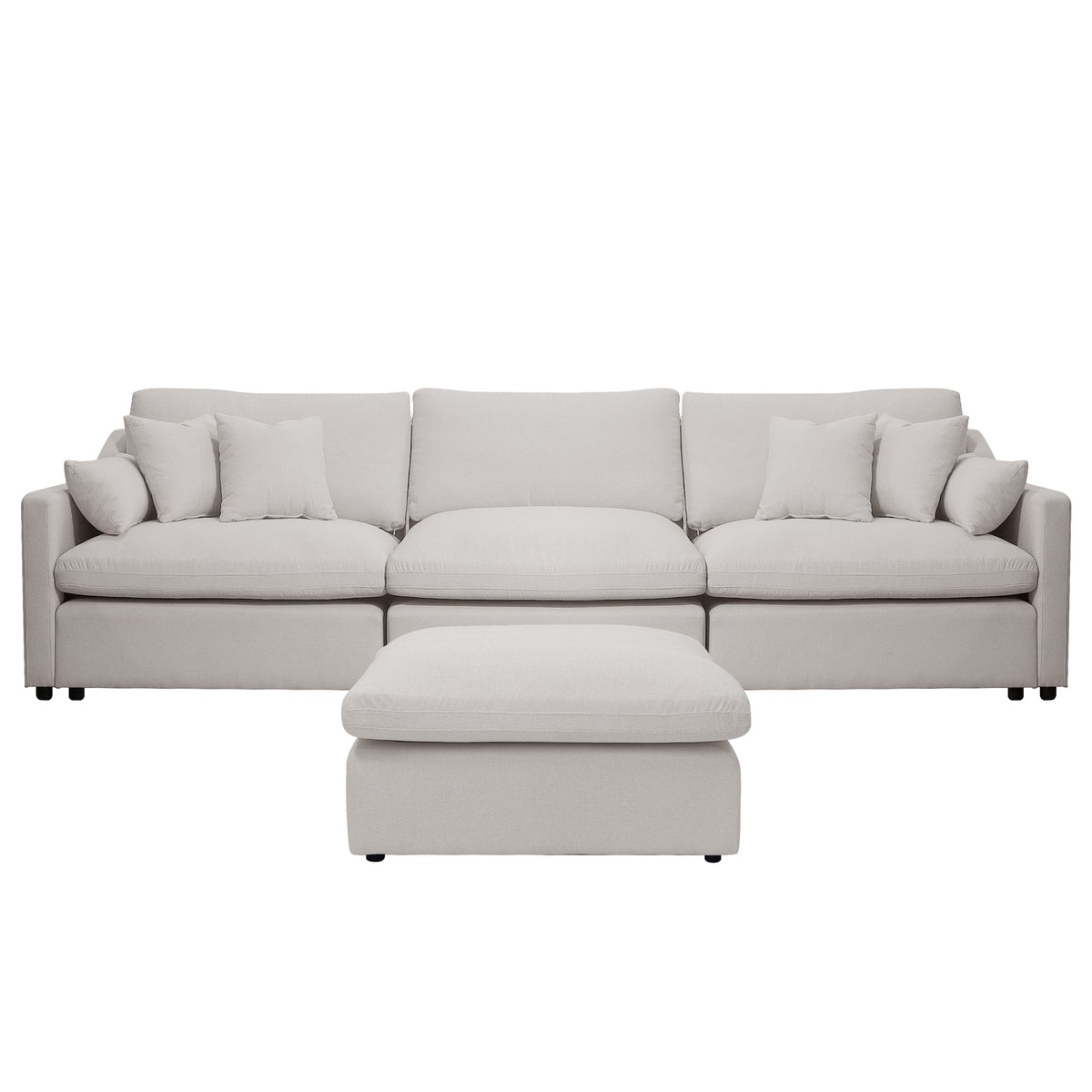Light beige upholstered sofa with ottoman and pillows on a white background