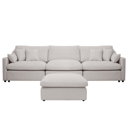 Light beige upholstered sofa with ottoman and pillows on a white background