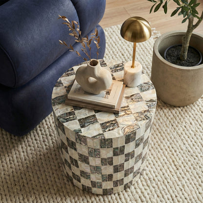 Checkered side table in lifestyle setting with chair and plant