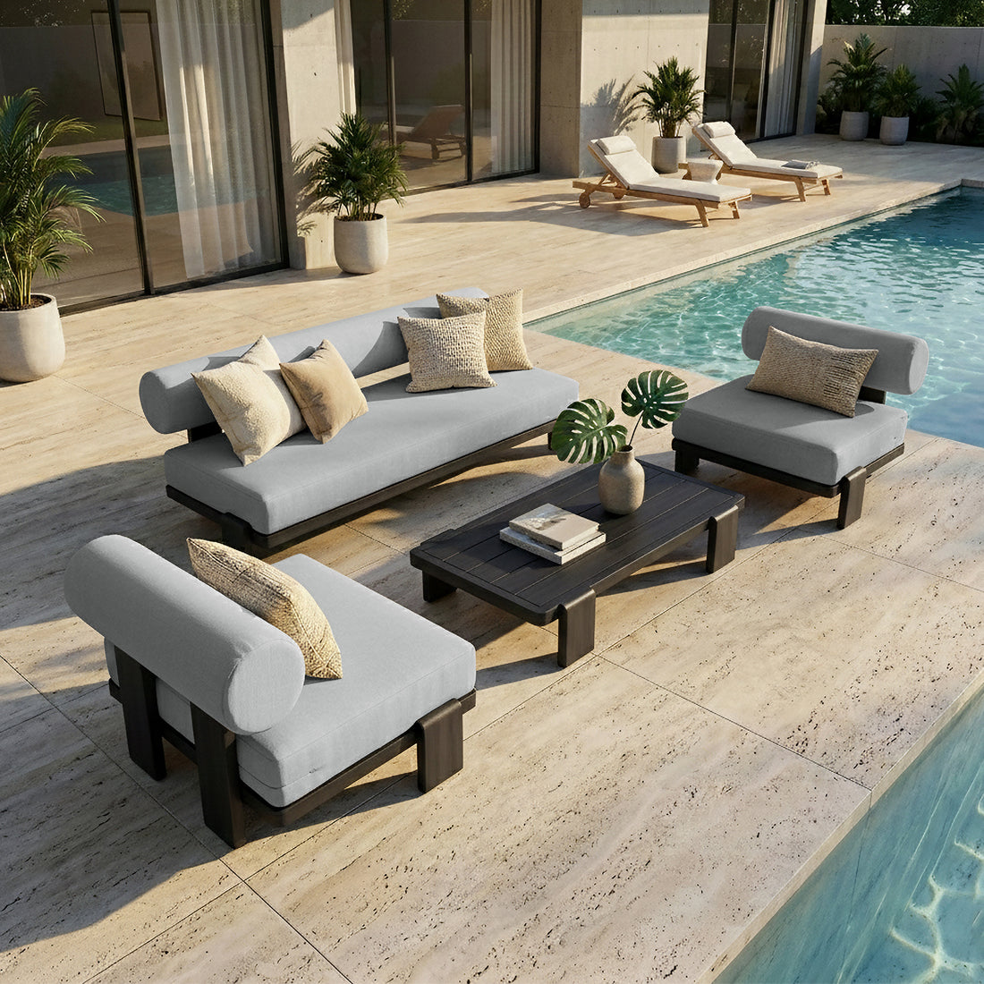 Modica 5 Seater Aluminium Outdoor Sofa Set in Black & Grey features sleek, low-profile design with thick gray cushions and neutral pillows, nestled beside a pool on light-tone stone tiles.