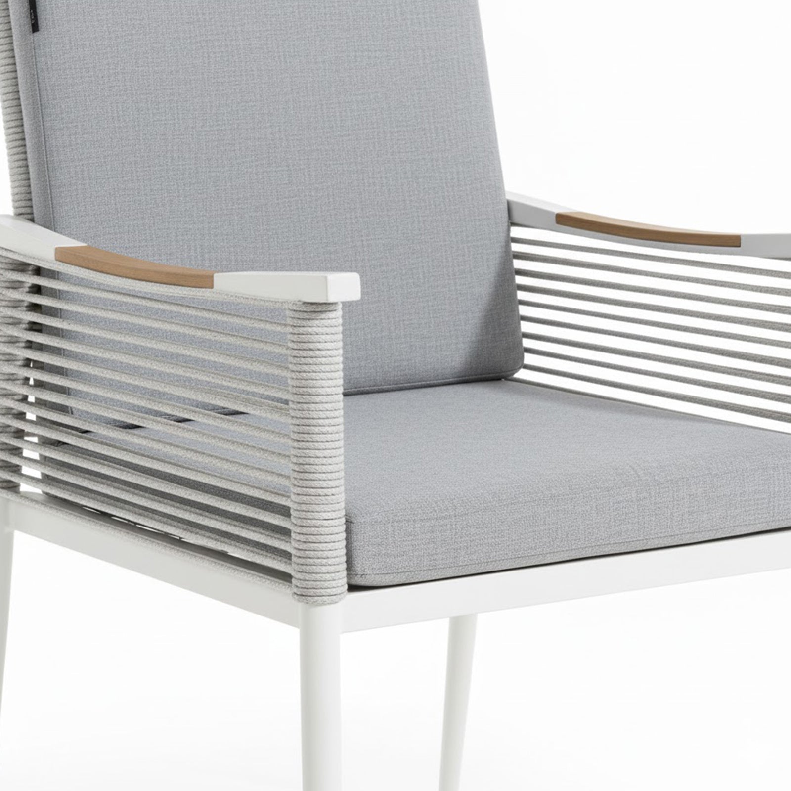 Casara 7 Piece Outdoor Dining Set in White & Grey features a modern armchair with a white metal frame, light-gray rope cord back, and wooden armrest accents, complemented by matching cushions.