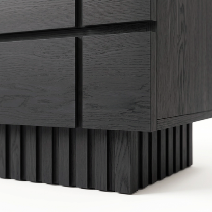 Close-up of the lower corner and textured base of a black wooden nightstand