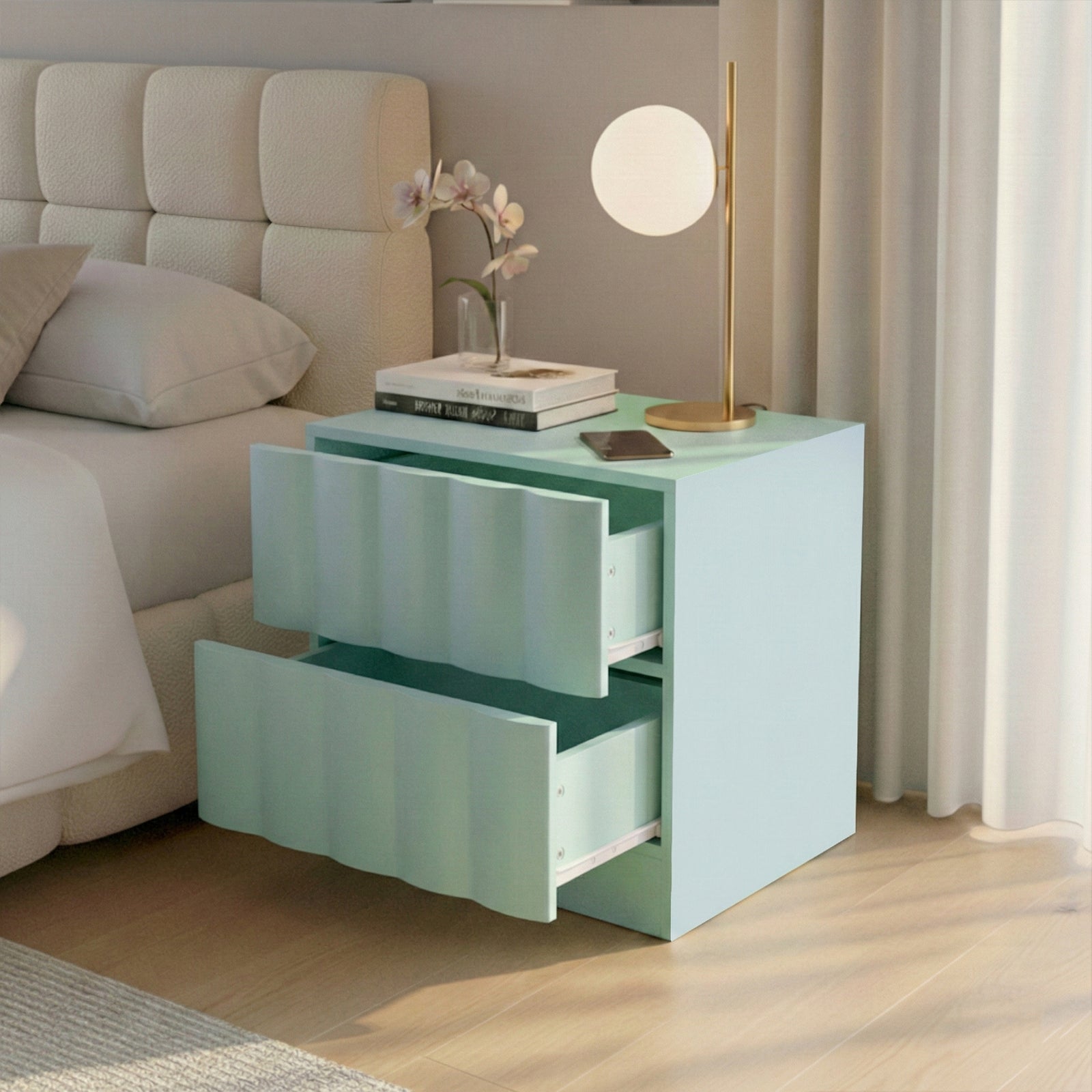 Pastel blue bedside table beside bed with lamp, books, vase, and smartphone