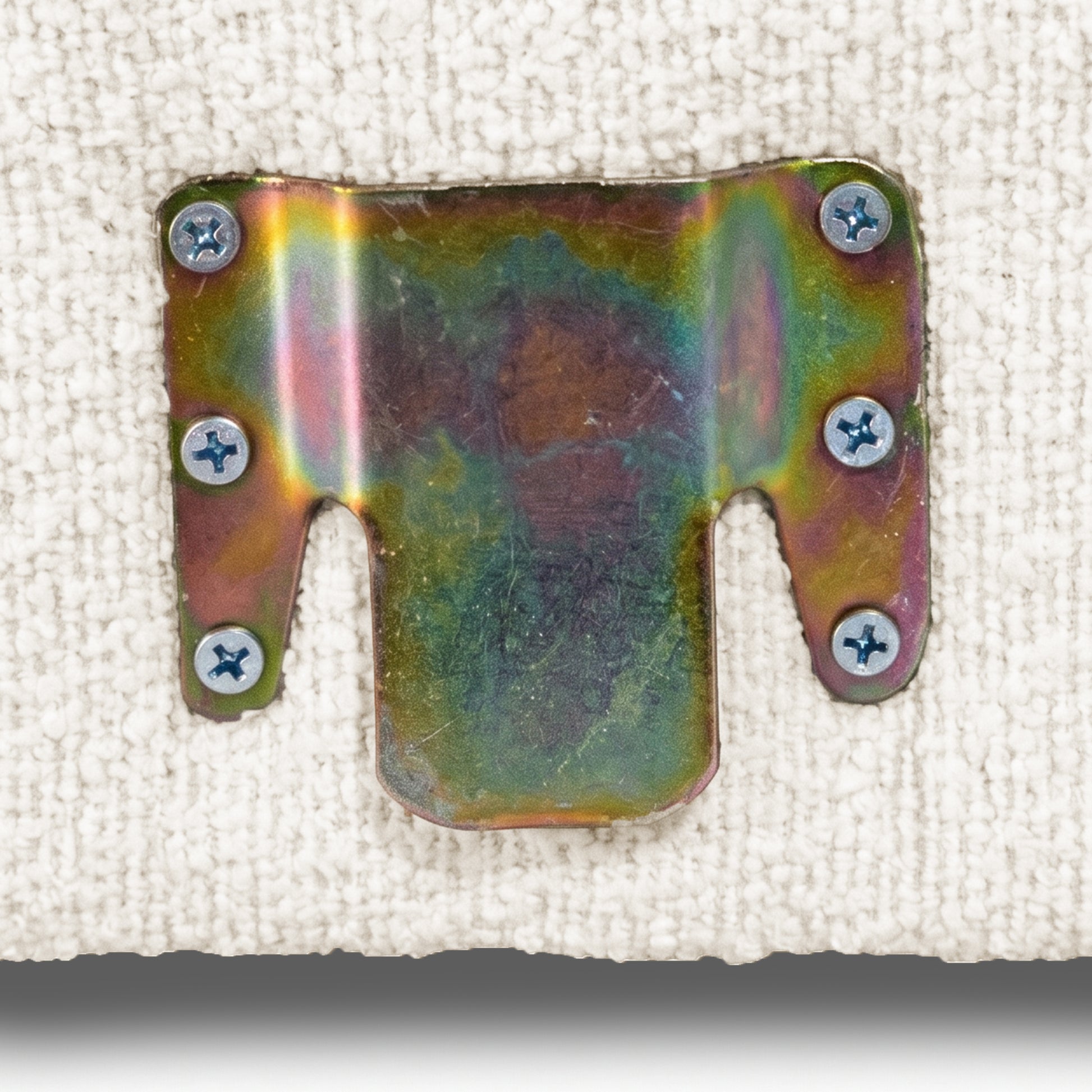 Detail of metal furniture bracket secured to upholstered fabric
