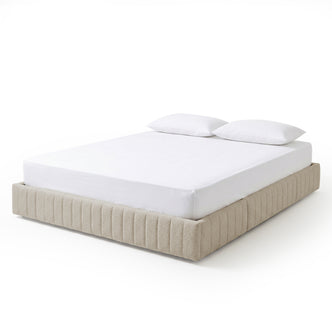 Modern light beige upholstered bed with white mattress and pillows on a white background