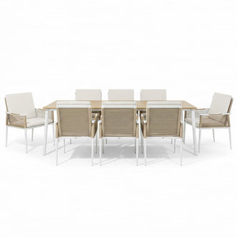Casara 9 Piece Outdoor Dining Set in White and Beige features a light-wood table with white metal legs, six side chairs, and two armchairs with beige rope-woven backs and cushioned seats.