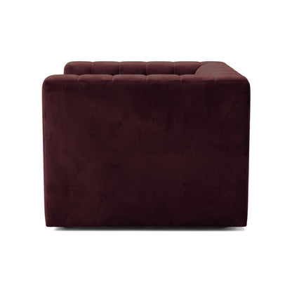 Side view detail of a Dark Merlot upholstered armchair on white background
