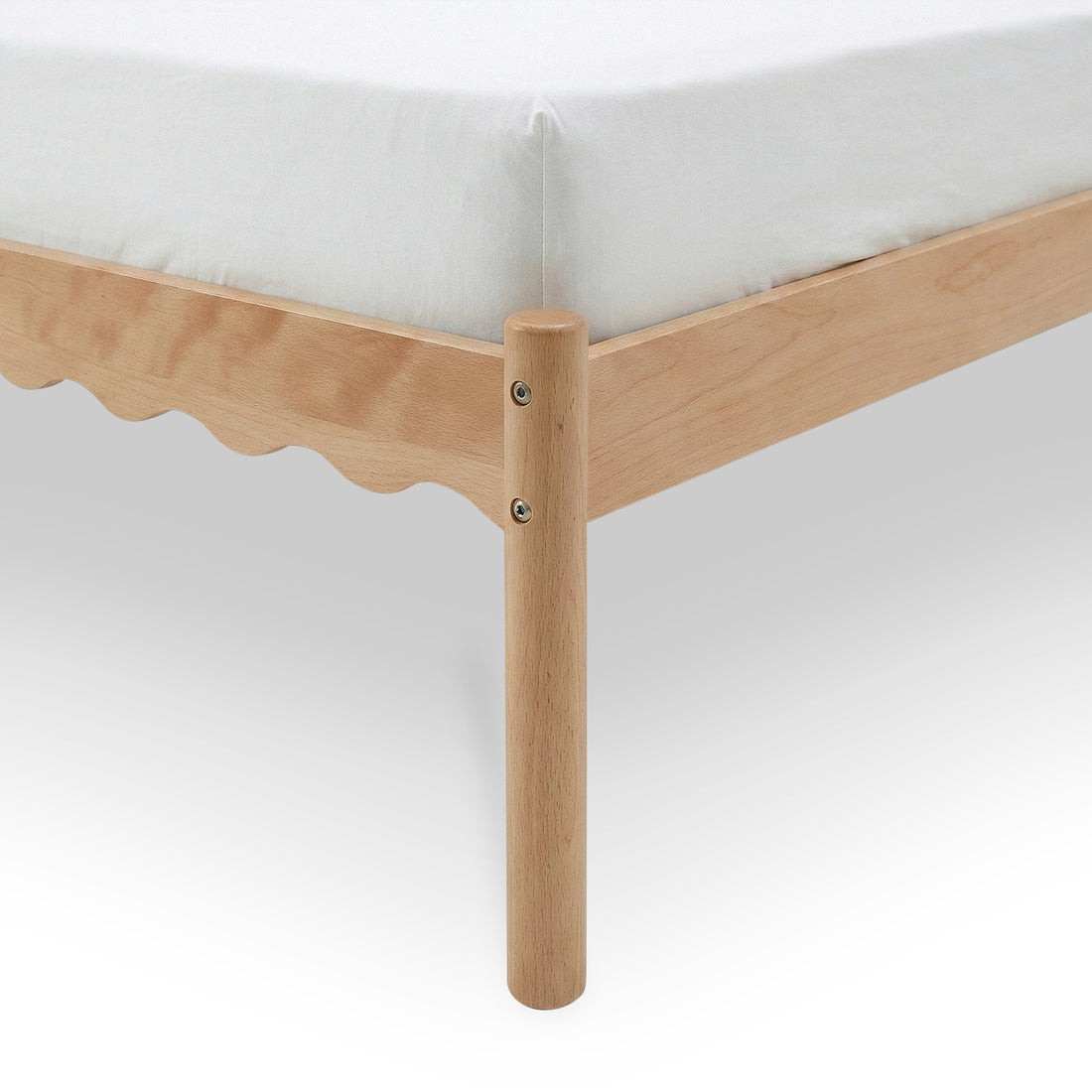 Close-up of wooden bed frame corner and round leg with scalloped side rail