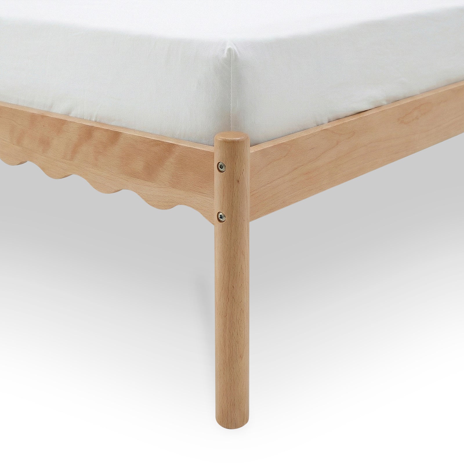 Close-up of wooden bed frame corner and round leg with scalloped side rail