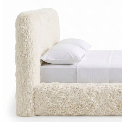 Close partial view of a cream faux-fur upholstered bed.