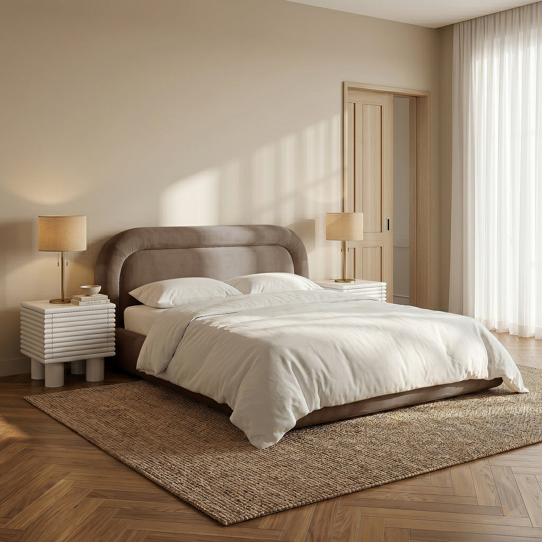 Taupe upholstered bed styled with cream bedding in a warm modern bedroom