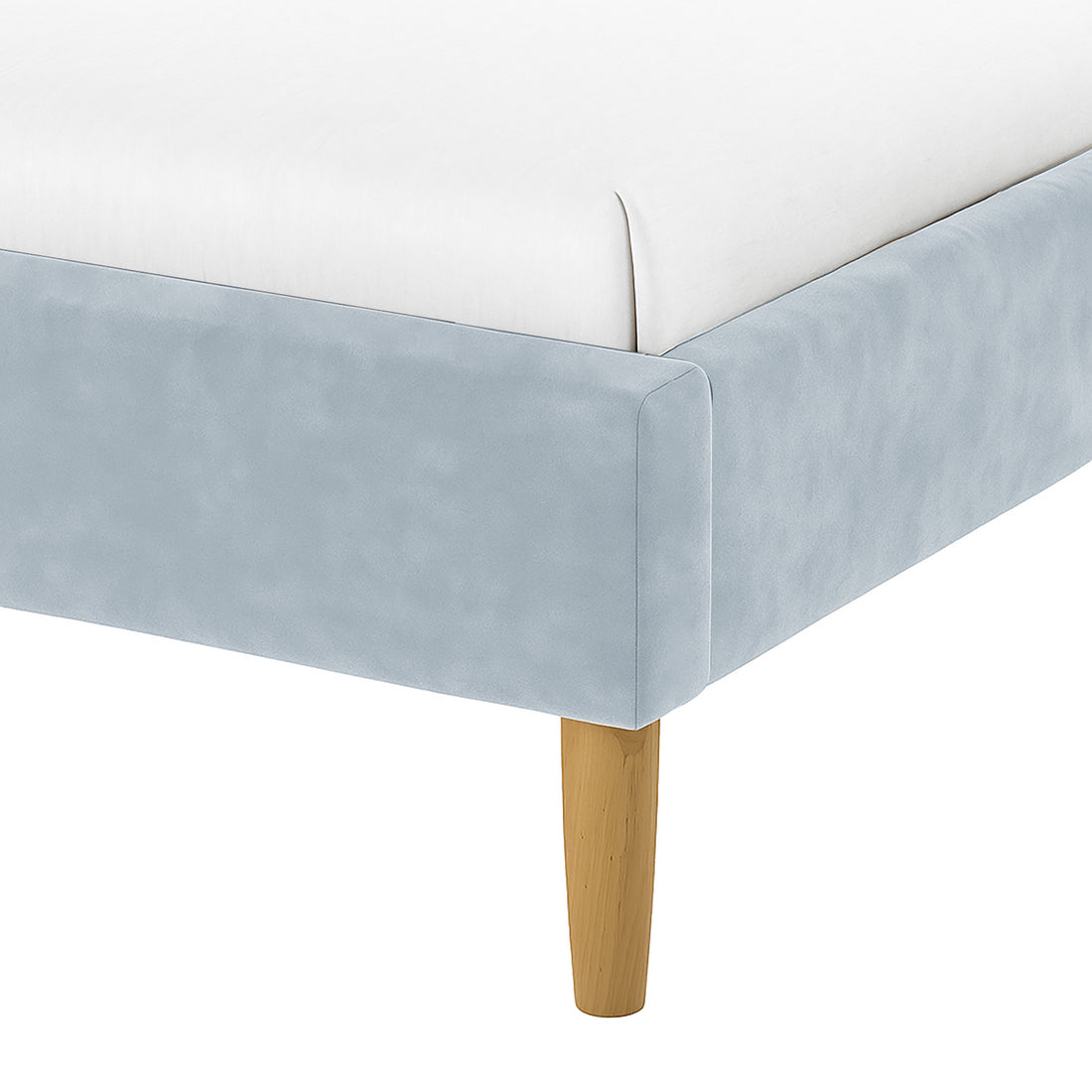 Close-up of the Estilla Velvet Rainbow Bed in Ice Blue, showcasing its pale blue fabric around the frame and a light wooden, tapered leg with a white mattress on top.