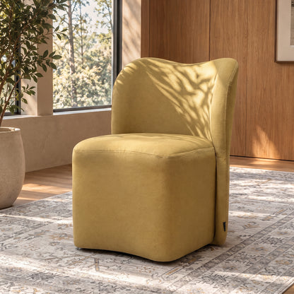 Mustard yellow upholstered chair in a stylish sunlit room with rug and plant