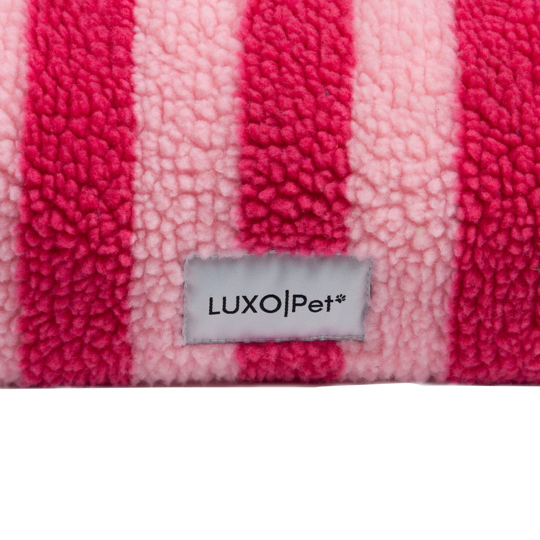 Close-up of pink and fuchsia striped fleece fabric with LUXO|Pet tag
